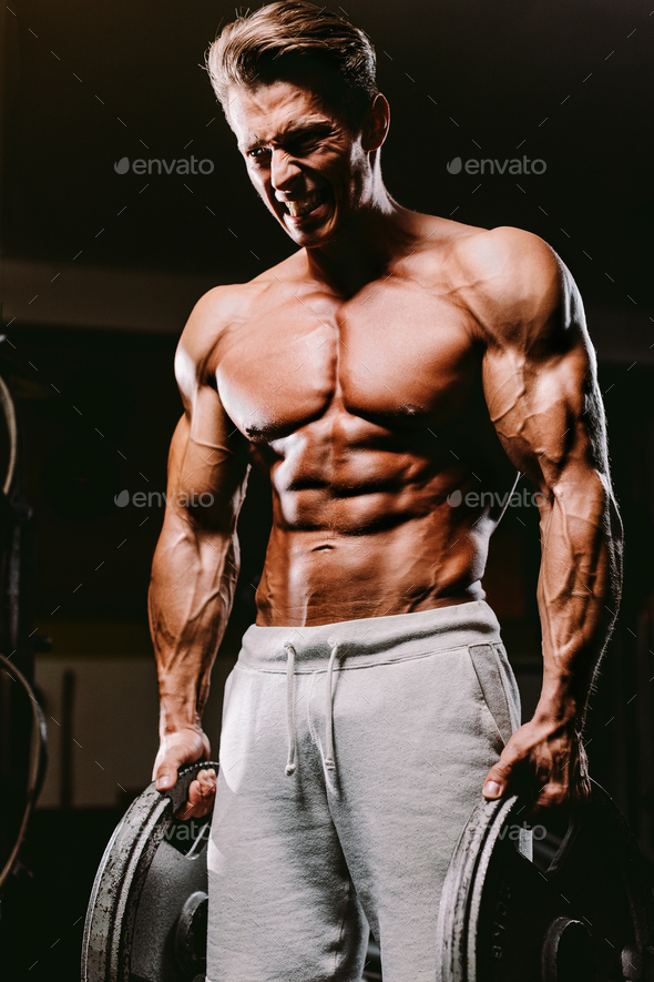 Muscular fit man pumping muscles. Stock Photo by avanti_photo PhotoDune